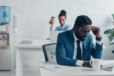 güzel yöneticisi yakınında ofiste otururken baş ağrısı muzdarip yorgun işadamı