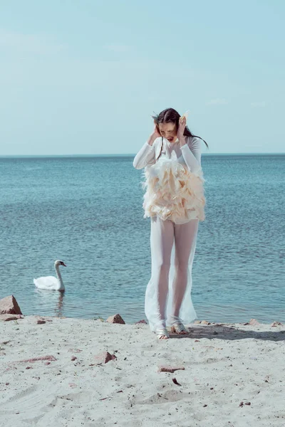 白鳥の衣装で叫ぶ大人の女性 砂浜でサンディング 鳥の近く — ストック写真