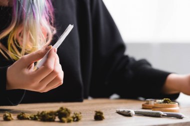 selective focus of girl holding joint with marijuana clipart