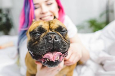 kapalı gözleri ve gülümseyen kız ile sevimli Frenchie seçici odak 