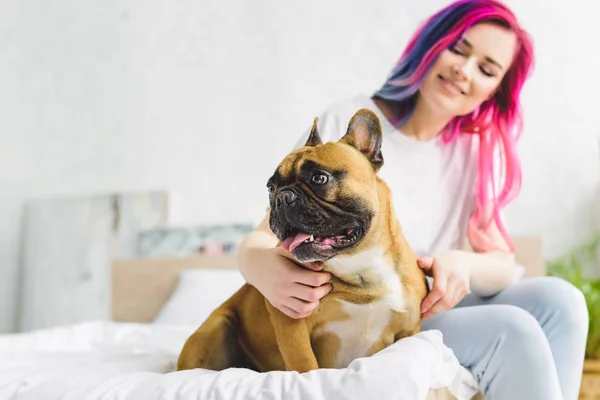 Yatakta Oturan Sevimli Bulldog Okşama Kız Seçici Odak Uzağa Bakarak — Stok fotoğraf