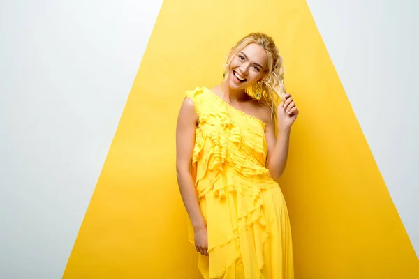 Felice Ragazza Bionda Toccare Capelli Mentre Posa Bianco Giallo — Foto Stock