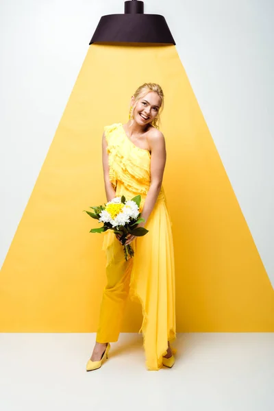 白と黄色に花束を持つ肯定的な若い女性 — ストック写真