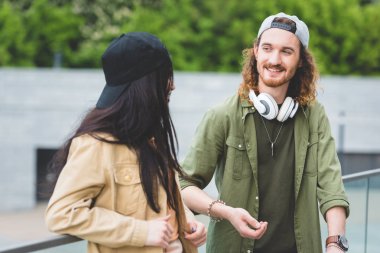 mutlu adam esmer kadın bakarak seçici odak, yeşil ağaçlar arka plan üzerinde duran