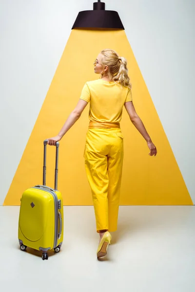 Ξανθιά Νεαρή Γυναίκα Περπάτημα Βαλίτσα Ενώ Και Κίτρινο — Φωτογραφία Αρχείου