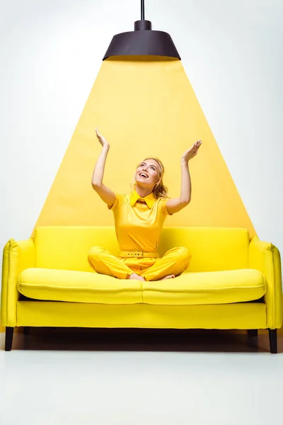Happy Blonde Girl Sitting Sofa Hands Head White Yellow — Stock Photo, Image