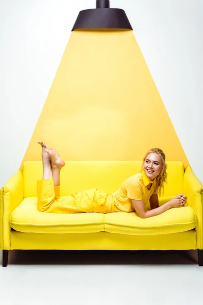 Cheerful Blonde Girl Barefoot Lying Sofa Smiling White Yellow — Stock Photo, Image