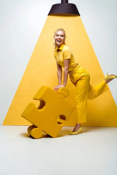Cheerful Blonde Woman Holding Big Soft Puzzle Piece White Yellow — Stock Photo, Image