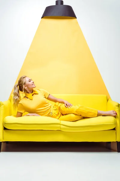 Happy Blonde Girl Barefoot Lying Sofa Smiling White Yellow — Stock Photo, Image