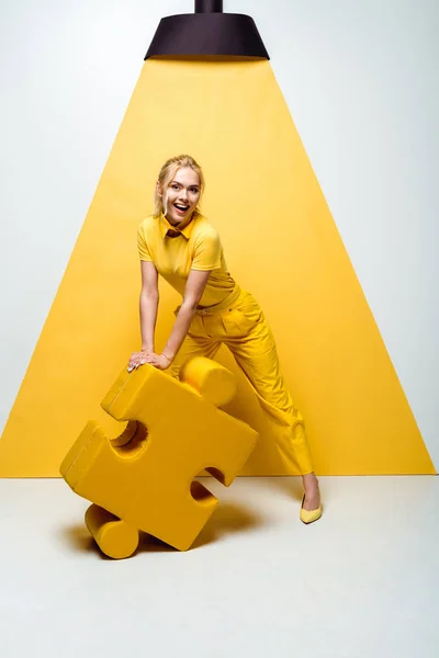 Happy Blonde Woman Holding Big Soft Puzzle Piece White Yellow — Stock Photo, Image