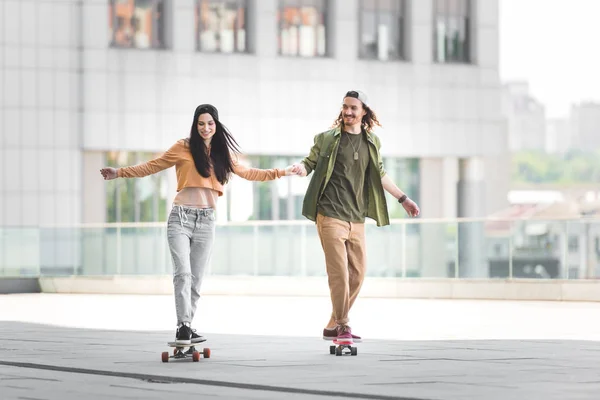 Hombre Feliz Cogido Mano Con Mujer Montar Monopatín Ciudad —  Fotos de Stock