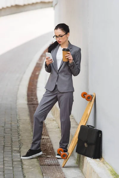 Ruhige Geschäftsfrau Die Mit Pappbecher Der Hand Neben Skateboard Steht — Stockfoto