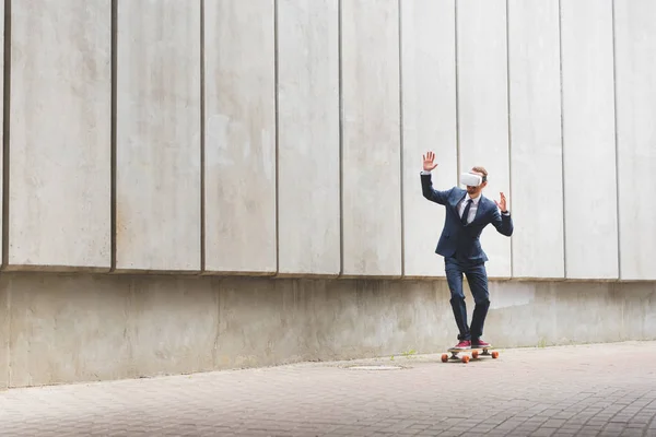 スケートボードに乗って 手を上げるフォーマルな服装とVrヘッドセットで穏やかなビジネスマン — ストック写真
