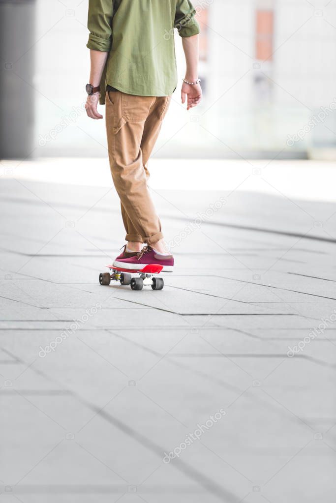 cropped view of man riding on penny board