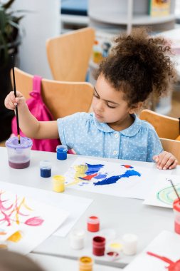 çizim ile kağıt yakınında paintbrush tutan Afrikalı Amerikalı çocuğun seçici odak 