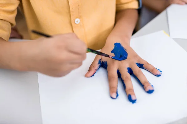 Vista Cortada Criança Segurando Pincel Enquanto Pintura Mão — Fotografia de Stock