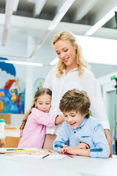 Niedliches Kind Umarmt Glückliche Frau Die Neben Entzückendem Jungen Steht — Stockfoto