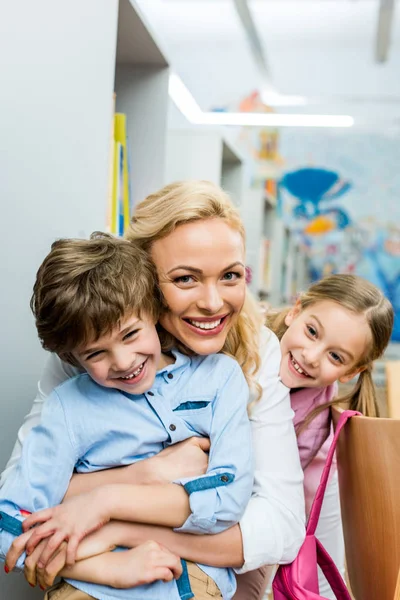 Feliz Mujer Abrazando Lindo Alegre Chico Cerca Sonriente Niño — Foto de Stock