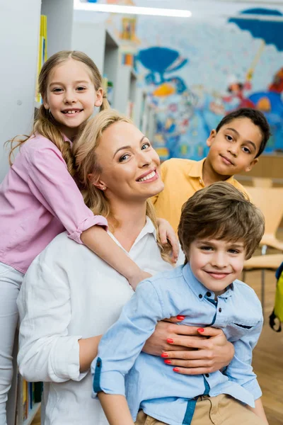 Fröhliches Kind Umarmt Attraktive Frau Der Nähe Multikultureller Jungen — Stockfoto