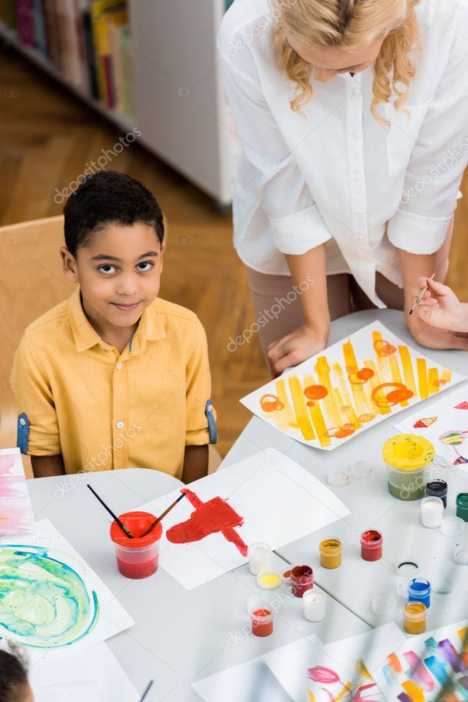overhead view of happy african american boy near teacher and kid 