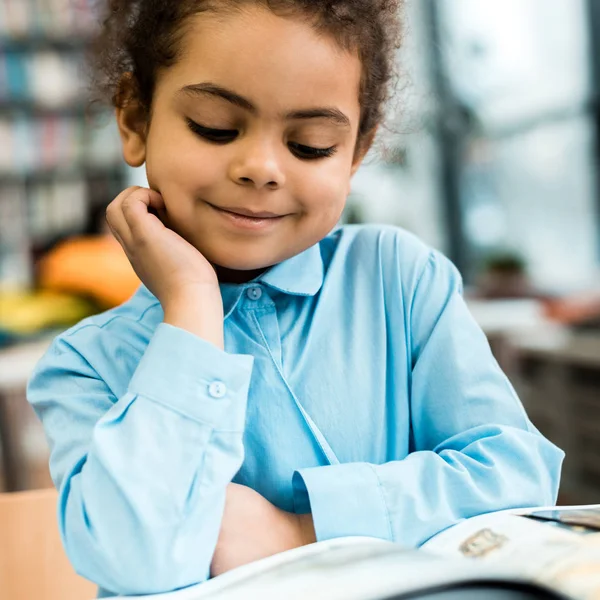 Foco Seletivo Criança Americana Africana Feliz Sorrindo Lendo Livro Mesa — Fotografia de Stock