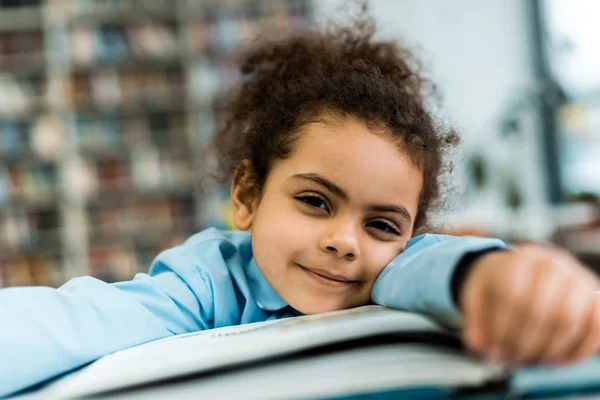 Selective Focus Cheerful African American Kid Smiling While Lying Book — Stock Photo, Image