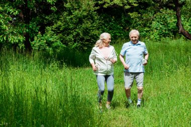 parkta koşarken kocasıbakarak gri saçlı kıdemli kadın 
