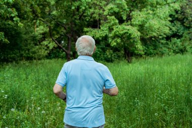 parkta duran spor giyim emekli adam geri görünümü 