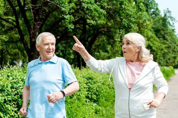 Überraschte Seniorin Zeigt Mit Finger Auf Mann Park — Stockfoto