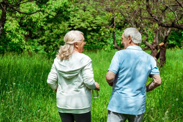 Ηλικιωμένη Γυναίκα Κοιτάζοντας Τον Σύζυγο Ενώ Τρέχουν Πράσινο Πάρκο — Φωτογραφία Αρχείου