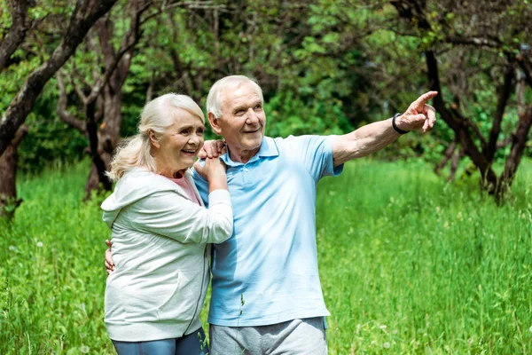 Cheerful Retired Man Pointing Finger Happy Wife Grey Hair — Stock Photo, Image
