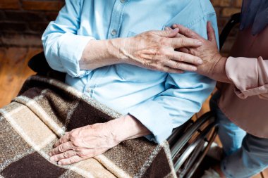 cropped view of senior disabled man holding hands with wife  clipart