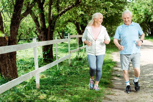 Cheerful Retired Man Running Senior Wife Park — Stock Photo, Image