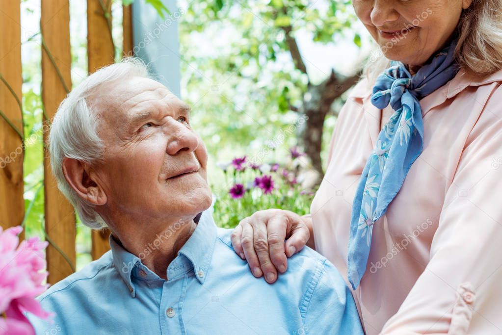 cropped view of cheerful retired woman standing near happy senior husband 