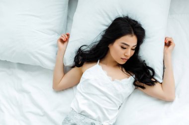 overhead view of attractive thai woman sleeping at home  clipart