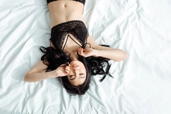침대에 섹시한 속옷에 타이어 여자의 상단보기 — 스톡 사진