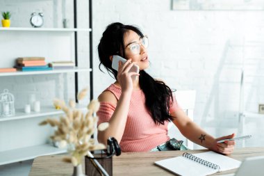 ofiste akıllı telefon konuşurken gözlük çekici Asya iş kadını seçici odak 