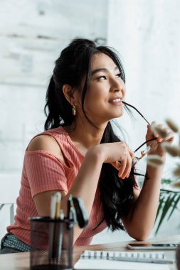 gözlük tutan neşeli asyalı kadın seçici odak 