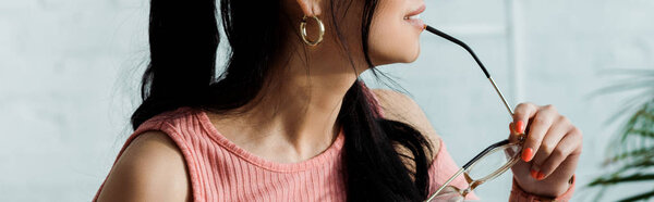 панорамный снимок молодой женщины, держащей газы у губ
 