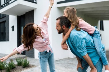 uzanmış elleri ile neşeli karısı yakın mutlu adam piggybacking kızı 