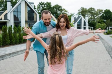 mutlu ebeveynler yakınında ayakta elleri ile çocuk arka görünümü 
