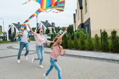 sokakta neşeli anne yakın renkli uçurtma ile çalışan mutlu çocuk 