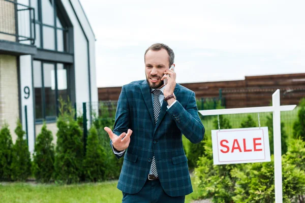 Corretor Emocional Gesticulando Enquanto Fala Smartphone Perto Placa Com Cartas — Fotografia de Stock