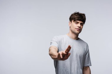 displeased man showing stop gesture isolated on grey, human emotion and expression concept clipart