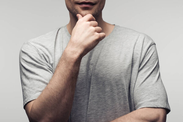 partial view of man holding hand near face isolated on grey, human emotion and expression concept