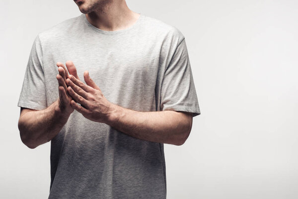 cropped view of man rubbing hands isolated on grey, human emotion and expression concept