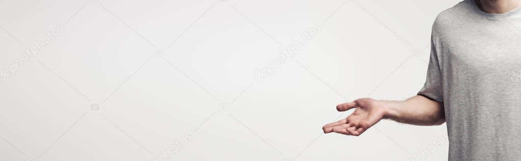 partial view of man showing shrug gesture isolated on grey background, human emotion and expression concept