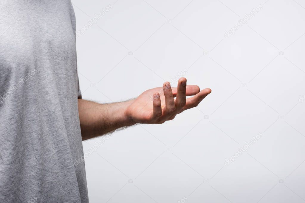 partial view of man gesturing with hand while using body language isolated on grey, human emotion and expression concept