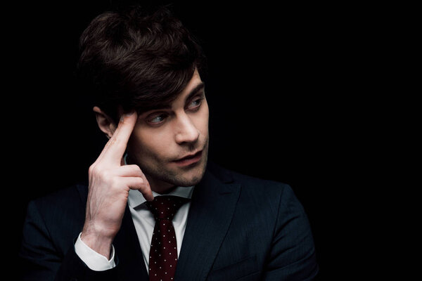 задумчивый бизнесмен смотрит в сторону, держа за голову, изолированную от черных, человеческих эмоций и выражений
