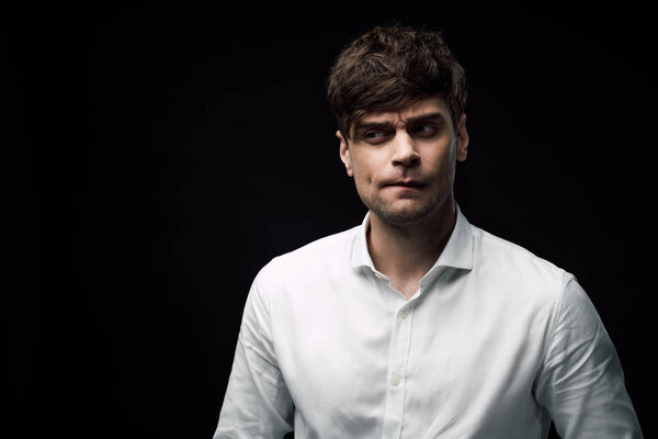 скептически настроенный бизнесмен гримасничает и смотрит в сторону изолированного от черного
 